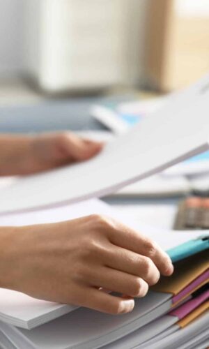 Office employee working with documents at table, closeup Les démarches pour louer son logement sur Airbnb