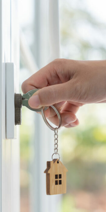 Landlord key for unlocking house is plugged into the door. Secon Landlord key for unlocking house is plugged into the door. Second hand house for rent and sale. keychain is blowing in the wind. mortgage for new home, buy, sell, renovate, investment, owner, estate